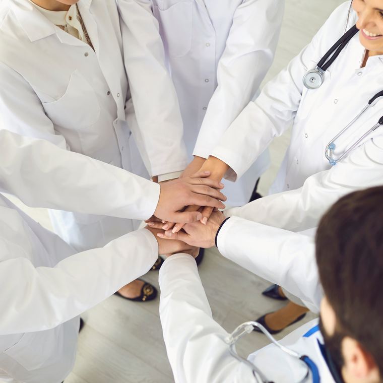 Equipe médica unida com as mãos ao centro