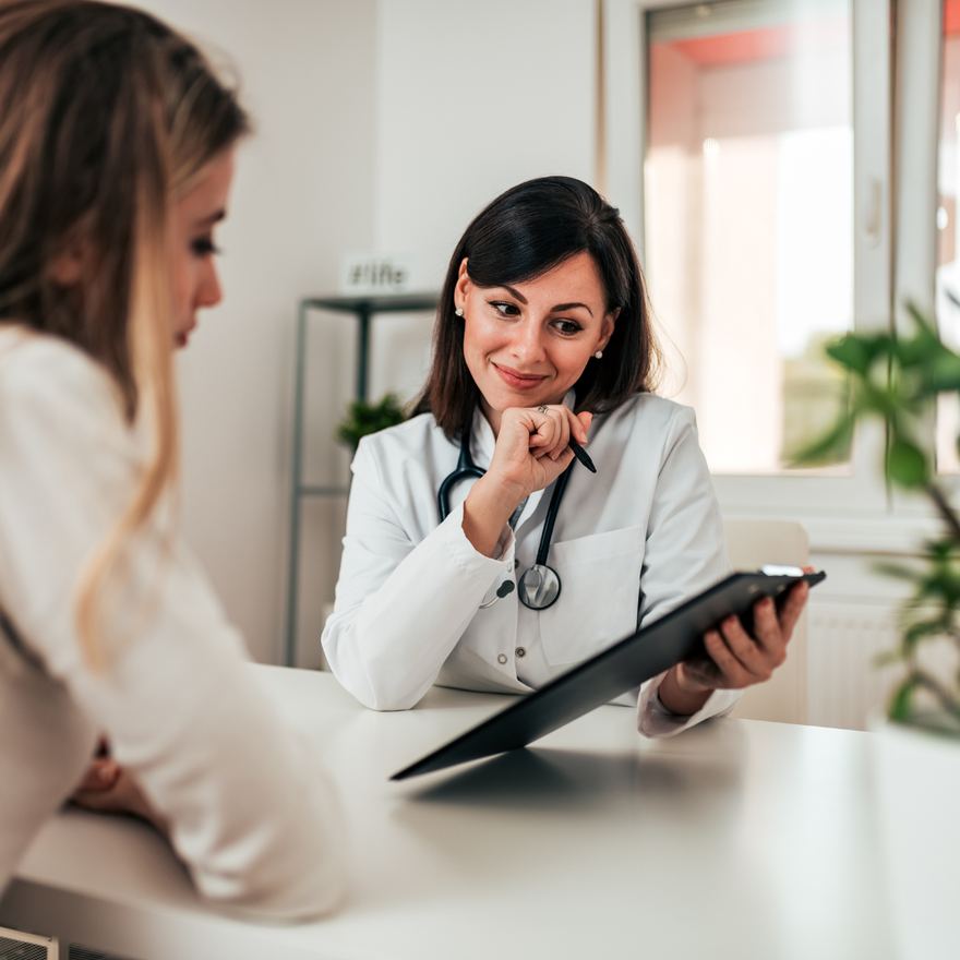 Médica orientando paciente durante atendimento
